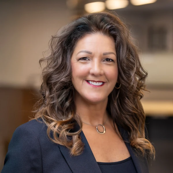 Professional headshot over a blurred background.