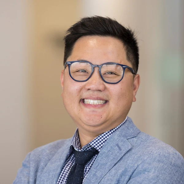 Professional headshot over a blurred background.