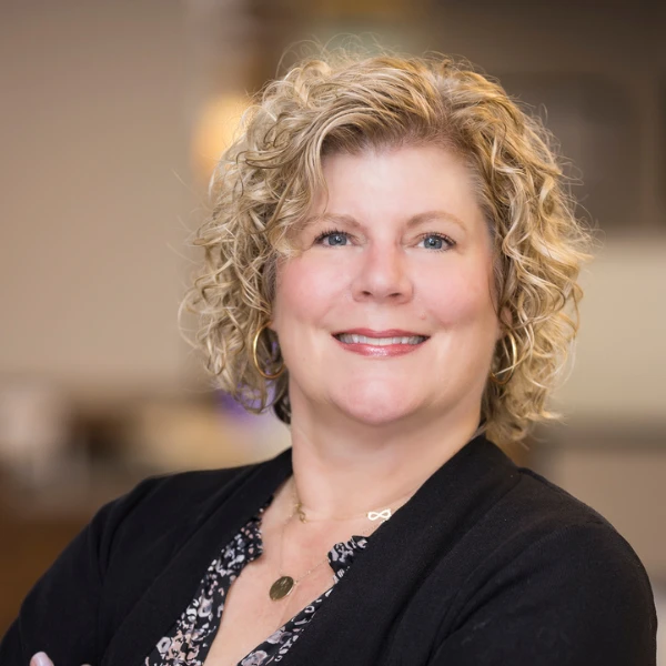 Professional headshot over a blurred background.