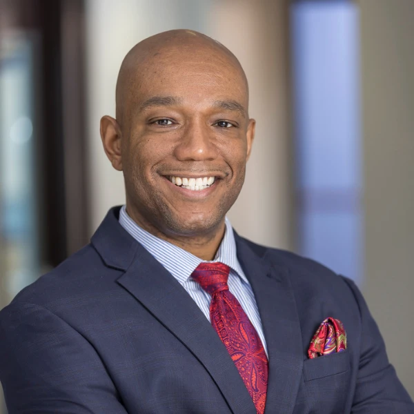 Professional headshot over a blurred background.