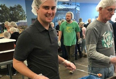 People in hair nets serving food